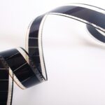 Close-up of a curled filmstrip against a white background, emphasizing vintage cinema.